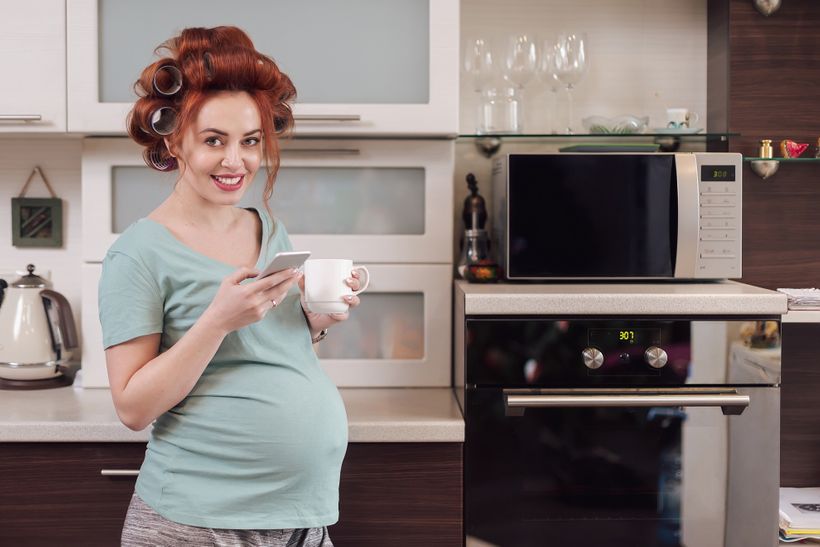 Tehotná žena držiaca čierny čaj