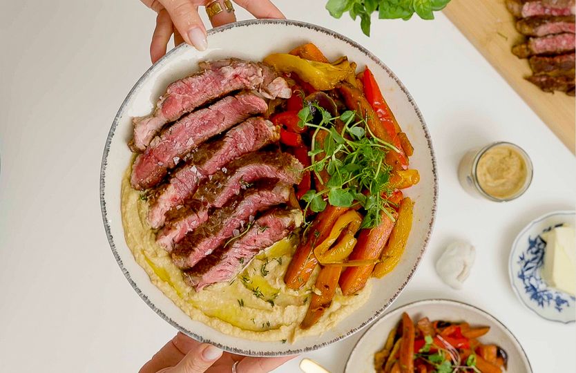 Steak with roasted vegetables and hummus